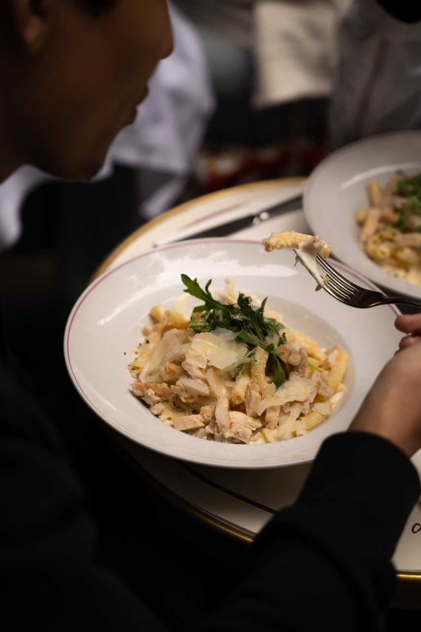 Assiette de pâtes au poulet, parmesan et roquette dégustée au restaurant