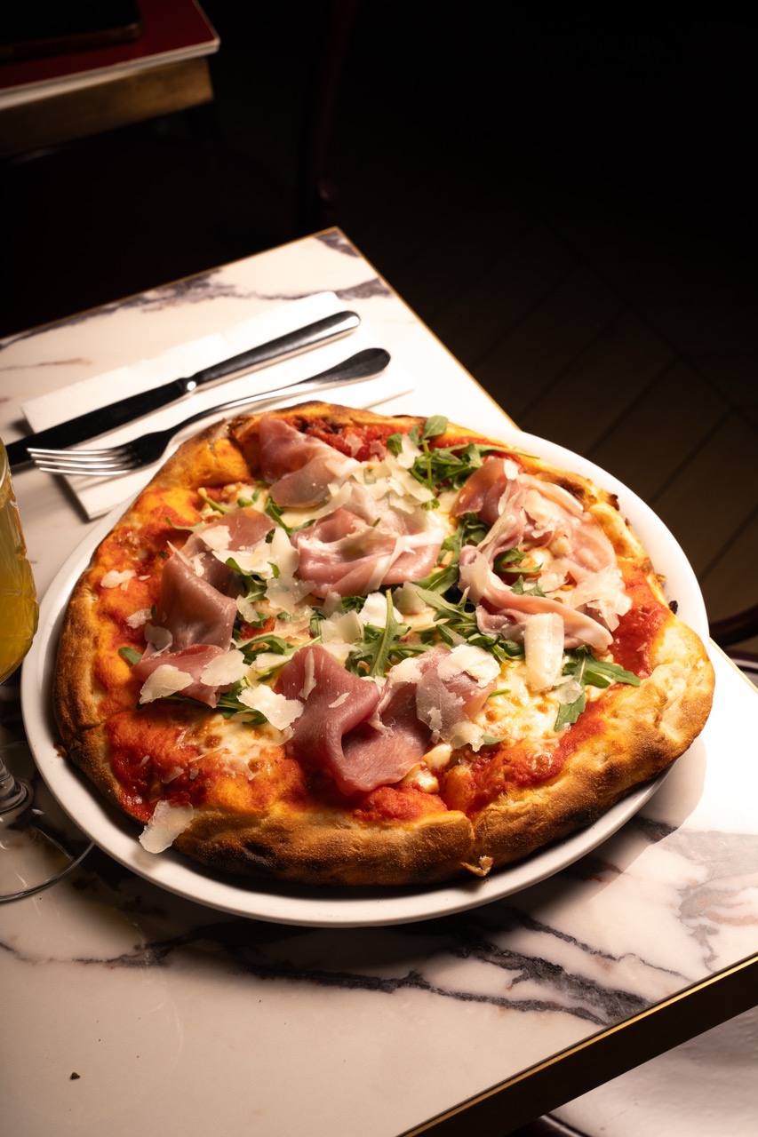 Pizza au jambon cru, roquette et copeaux de parmesan