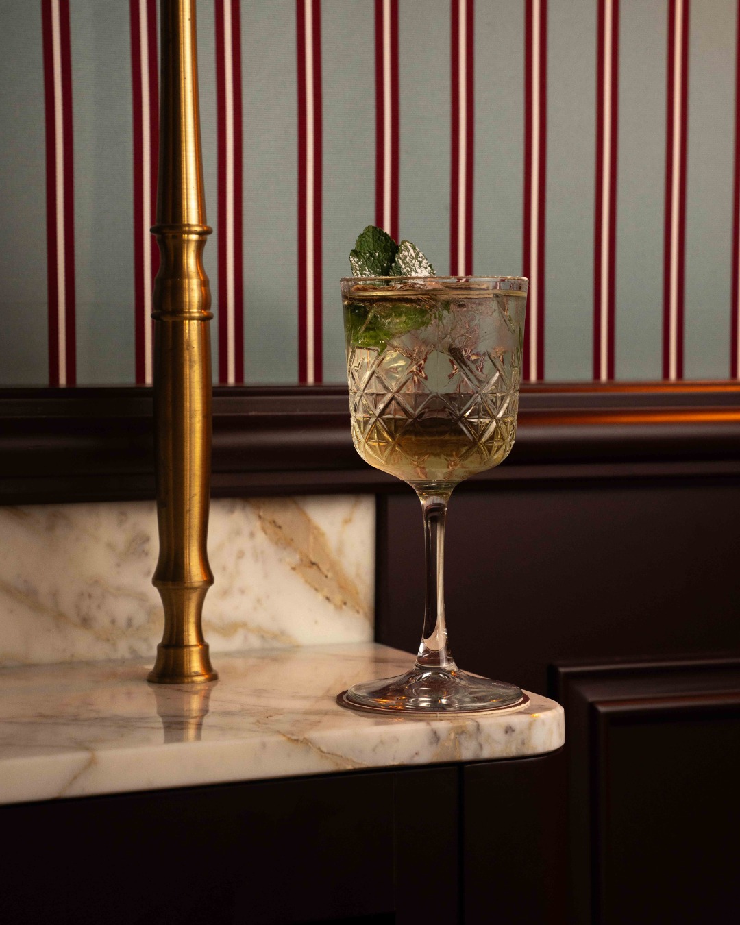 Cocktail à la menthe dans le décor bordeaux du restaurant
