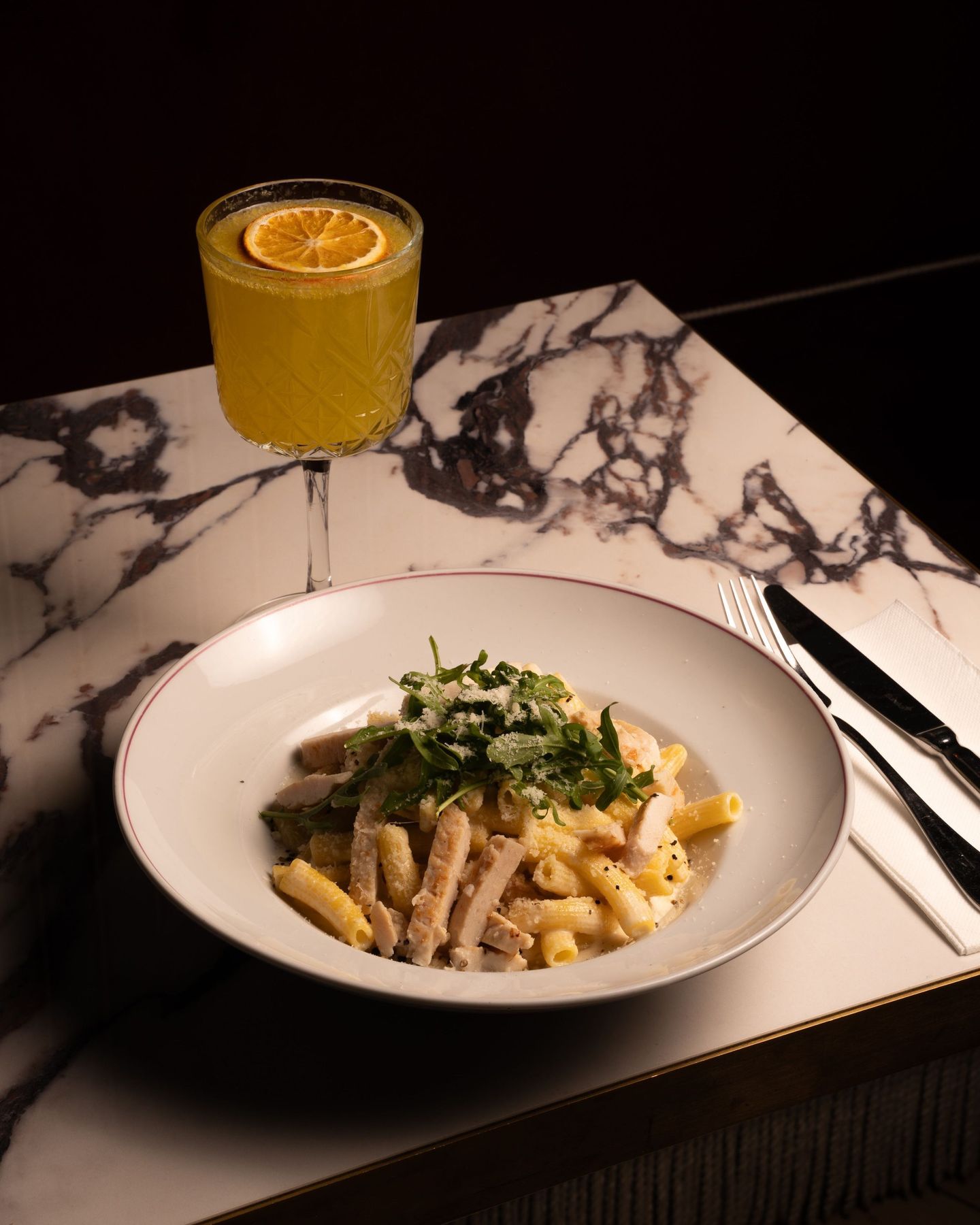 Assiette de pâtes, roquette et cocktail aux agrumes